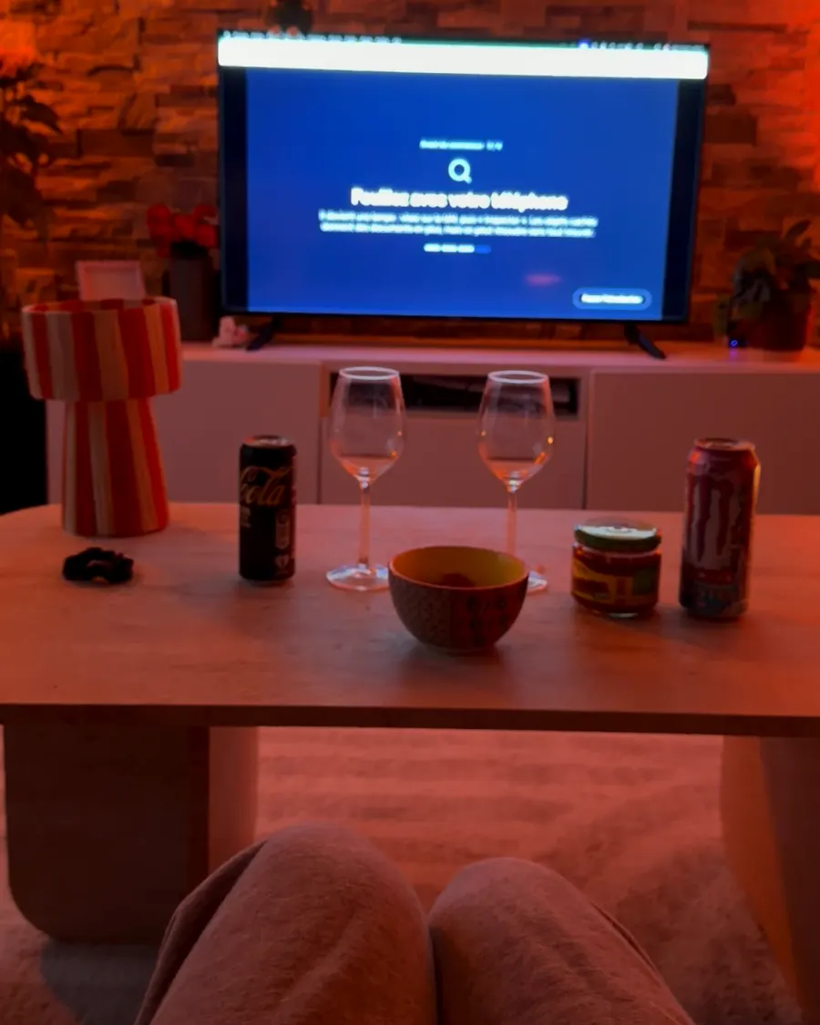 Vue depuis le canapé, plaid sur les genoux, la télé allumée